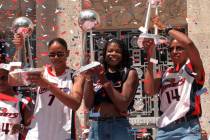 Houston Comets players Tina Thompson, left, Sheryl Swoopes, center, and Cynthia Cooper hoist th ...