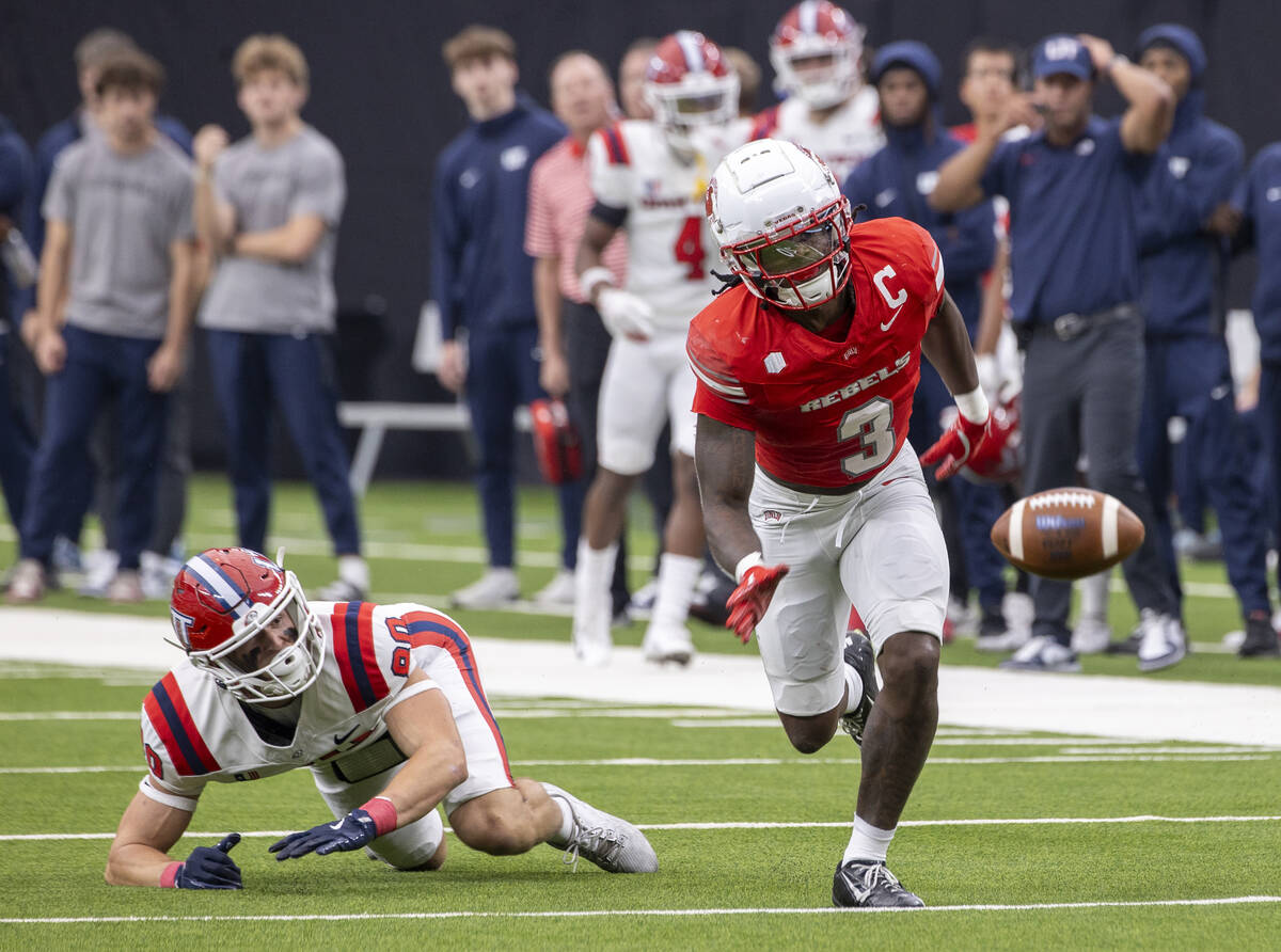 Utah Tech tight end Eric Olsen (80) and UNLV defensive back Johnathan Baldwin (3) run after a f ...