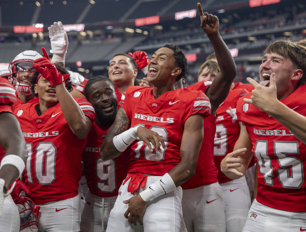 UNLV players celebrate their 72-14 win over Utah Tech with the UNLV Star of Nevada Marching Ban ...