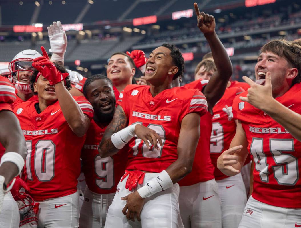 UNLV players celebrate their 72-14 win over Utah Tech with the UNLV Star of Nevada Marching Ban ...