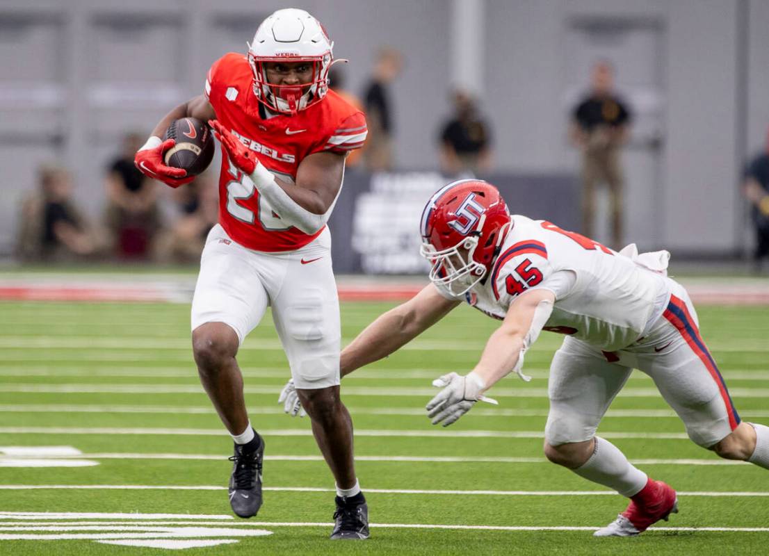 UNLV running back Michael Allen (26) outruns Utah Tech linebacker Spencer Rich (45) during the ...