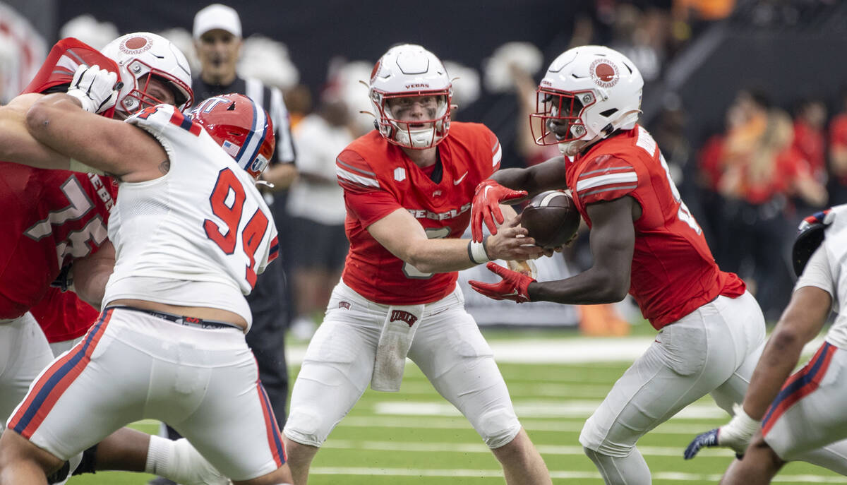 UNLV quarterback Matthew Sluka (3) hands the ball to running back Greg Burrell (5) during the c ...