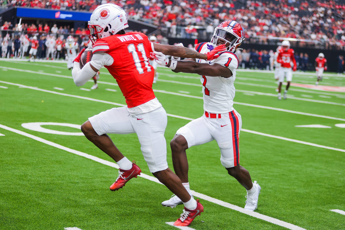 UNLV wide receiver Ricky White III (11) shoves off Utah Tech Trailblazers defensive back Scoote ...