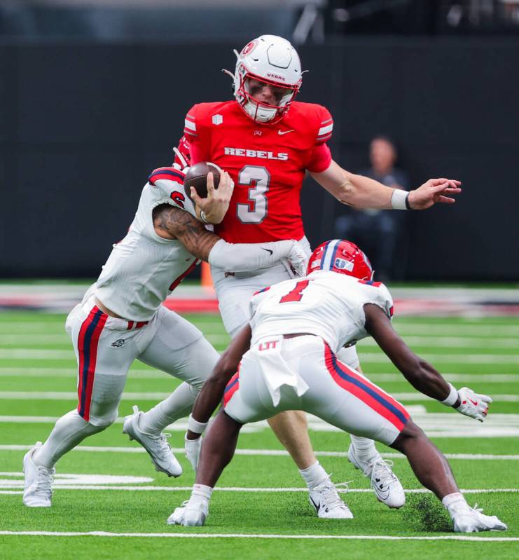 UNLV quarterback Matthew Sluka (3) is surrounded by Utah Tech defense during an NCAA football g ...