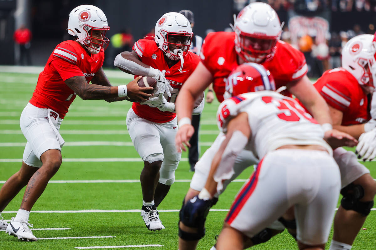 UNLV quarterback Cameron Friel (7) hands the ball off to UNLV running back Kylin James (20) dur ...