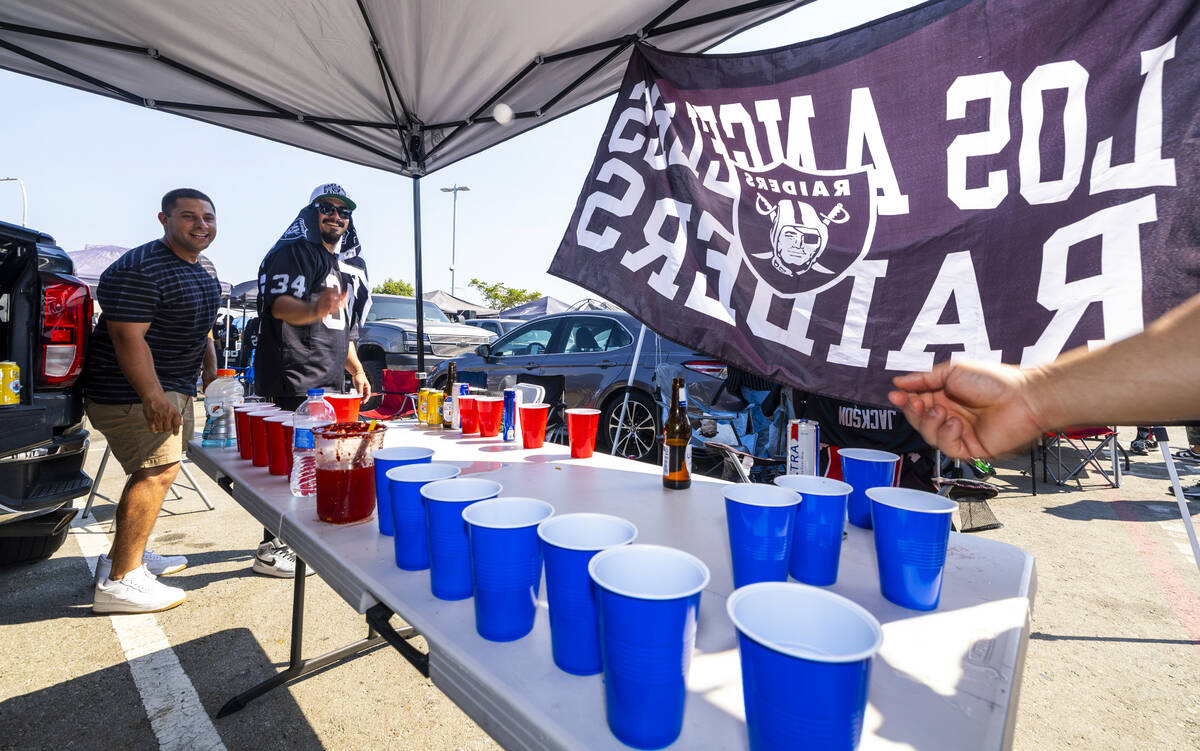 Fans play beer pong in the tailgate area before the Raiders face the Los Angeles Chargers in an ...