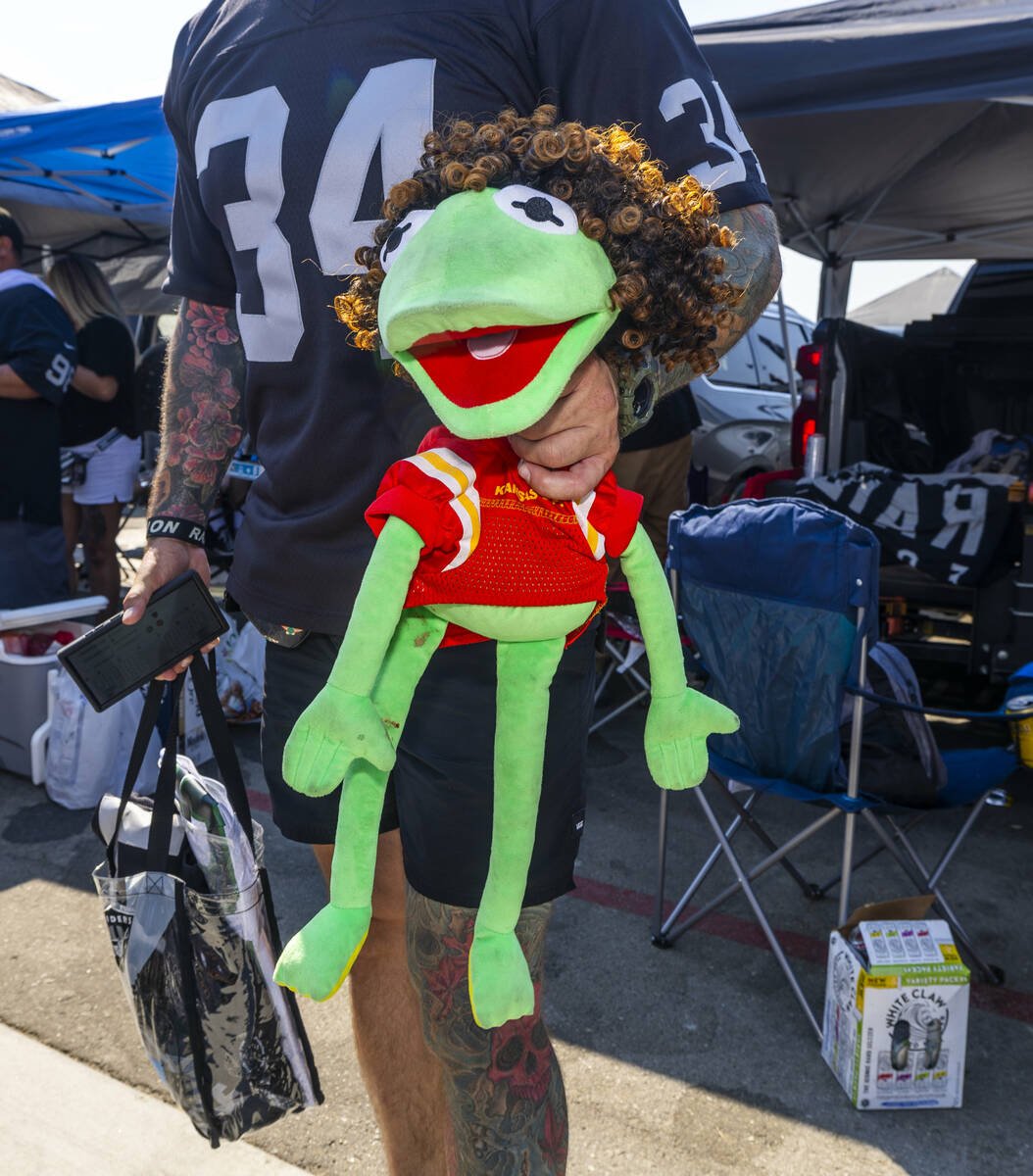 A fan holds a Kermit the Frog doll dressed as Patrick Mahomes in the tailgate area before the R ...