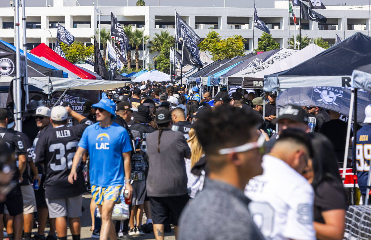 Fans from both teams wander about in the tailgate area before the Raiders face the Los Angeles ...