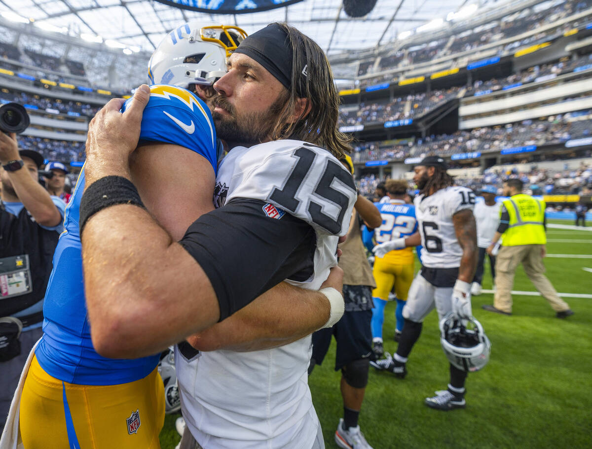 Raiders quarterback Gardner Minshew (15) gets a hug from Los Angeles Chargers quarterback Justi ...