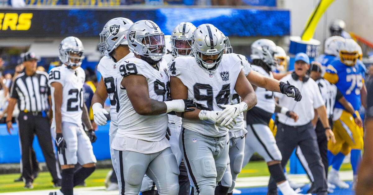 Raiders defensive tackle Christian Wilkins (94) holds his hand while being escorted off by defe ...