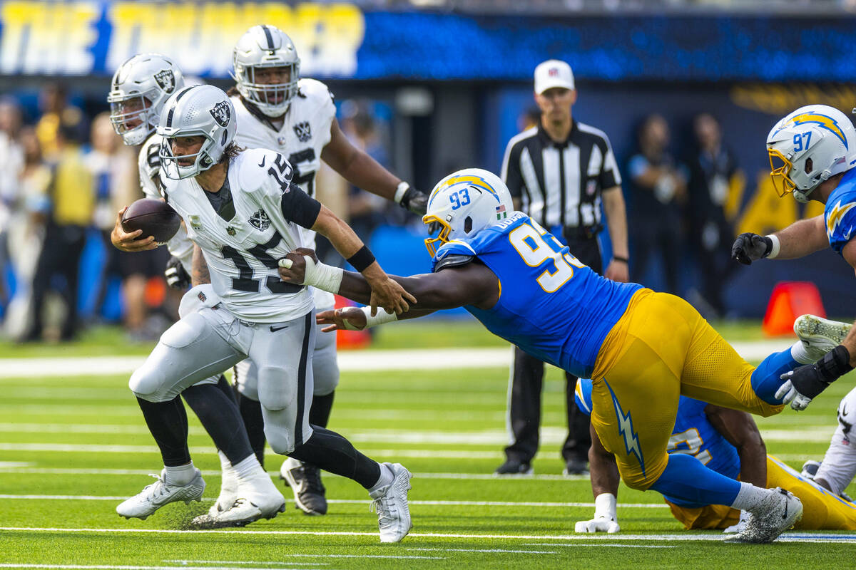 Raiders quarterback Gardner Minshew (15) breaks free for a run with a grab by Los Angeles Charg ...