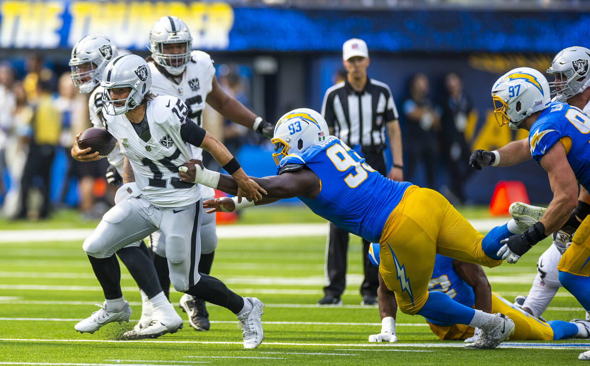 Raiders quarterback Gardner Minshew (15) breaks free for a run with a grab by Los Angeles Charg ...