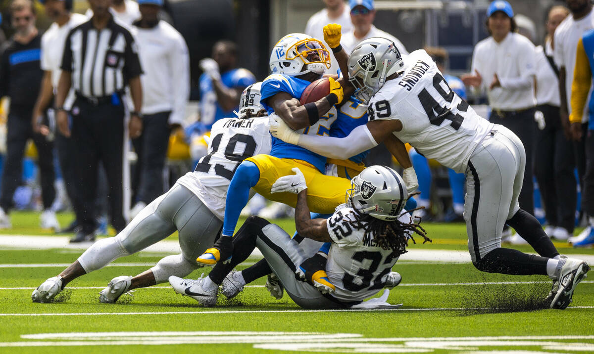 Los Angeles Chargers wide receiver Derius Davis (12) is gang tackled by Raiders defensive end C ...