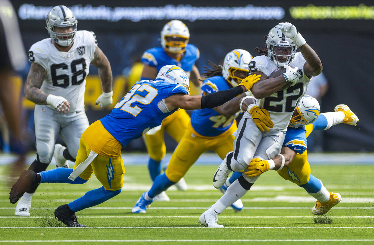 Raiders running back Alexander Mattison (22) is swarmed by Los Angeles Chargers defenders durin ...