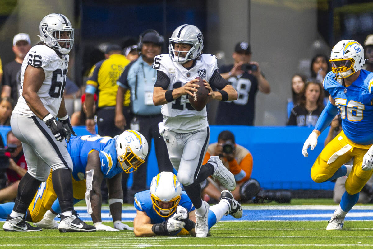 Raiders quarterback Gardner Minshew (15) takes off on a run and avoids a Los Angeles Chargers t ...