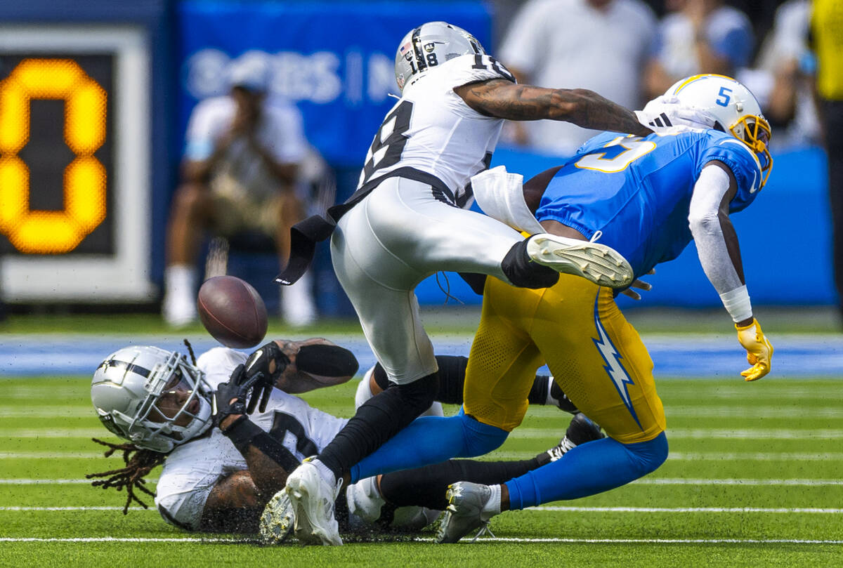 Raiders safety Tre'von Moehrig (7) attempts to secure a tipped ball from Los Angeles Chargers w ...