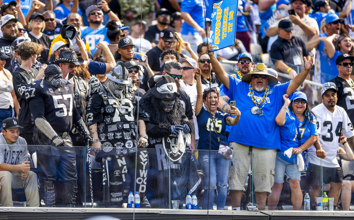 Raiders fans stand dejected as Los Angeles Chargers' fans celebrate a late touchdown during the ...