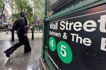 A rider passes an entrance to the Wall Street subway station in New York. (AP Photo/Peter Morgan)