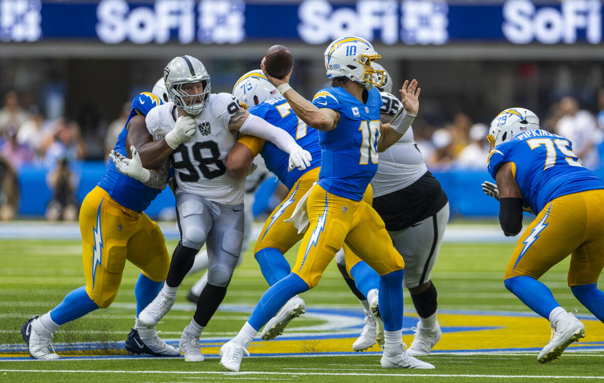 Raiders defensive end Maxx Crosby (98) is held while rushing to get to Los Angeles Chargers qua ...