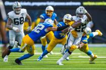 Raiders running back Alexander Mattison (22) is swarmed by Los Angeles Chargers defenders durin ...