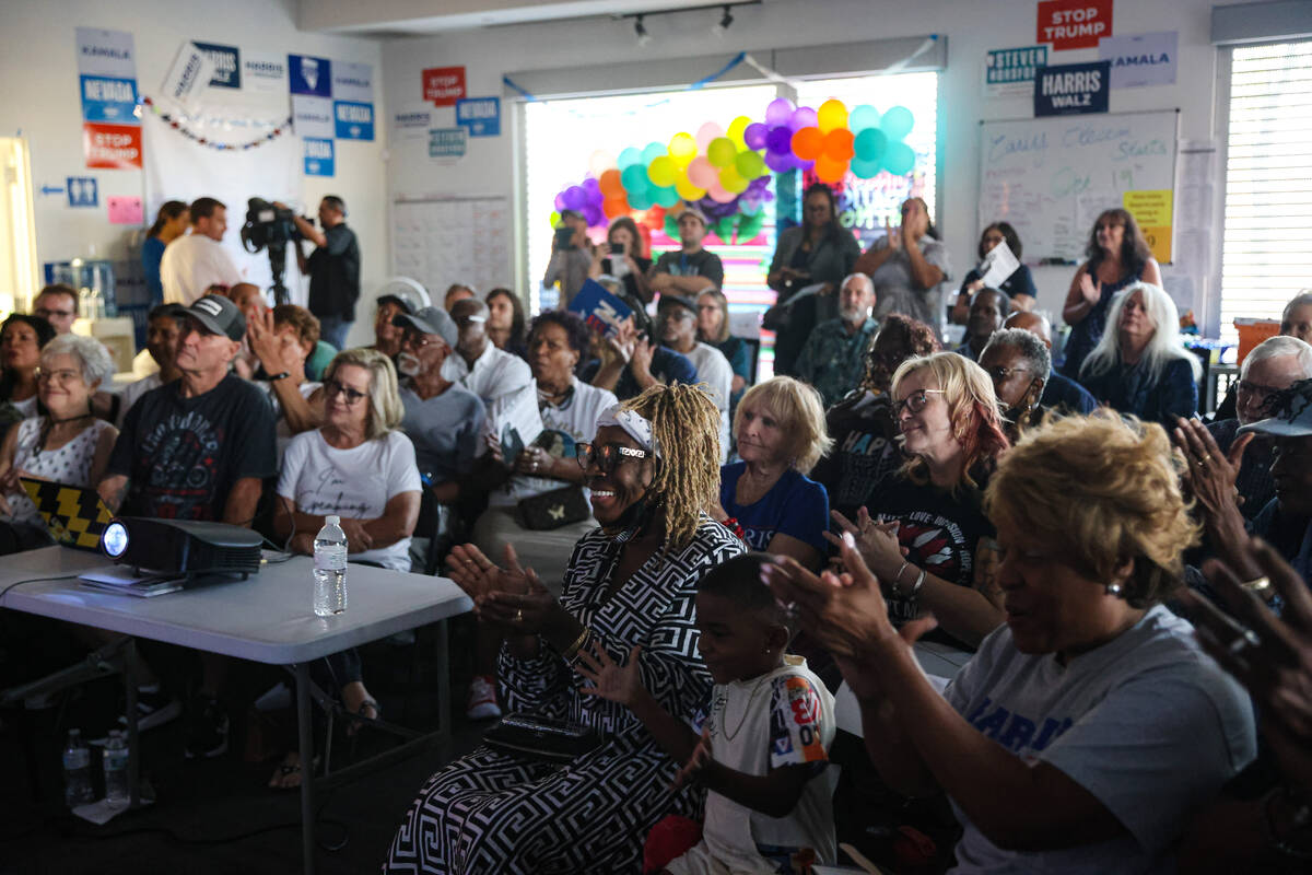 Tia Watson, center, reacts during a watch party of the presidential debate between Kamala Harri ...