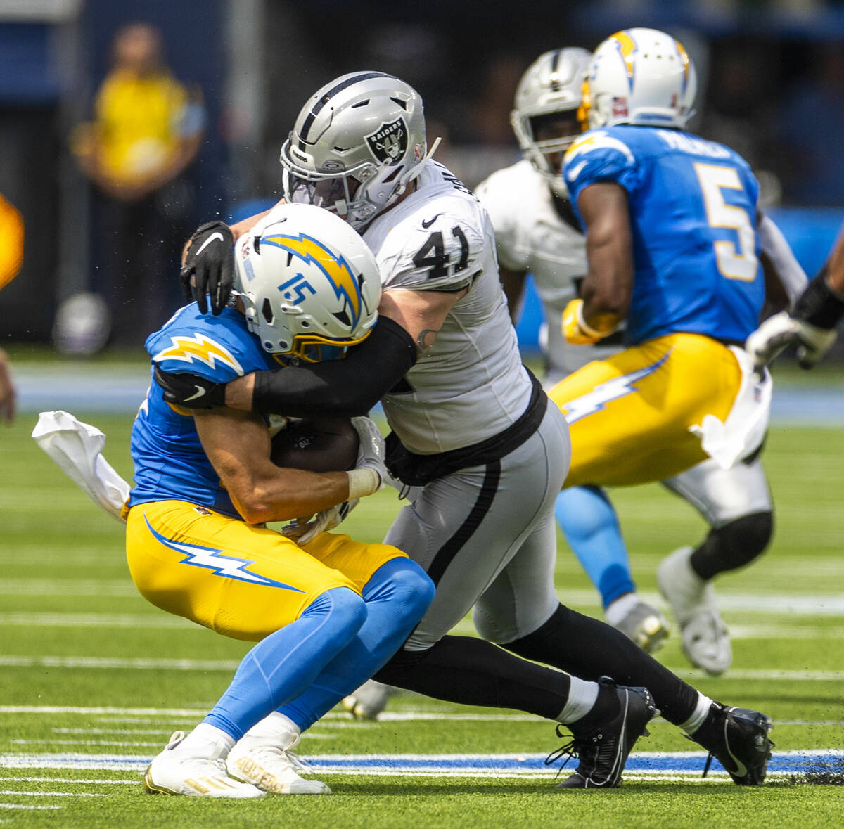 Los Angeles Chargers wide receiver Ladd McConkey (15) is wrapped up after a catch by Raiders li ...