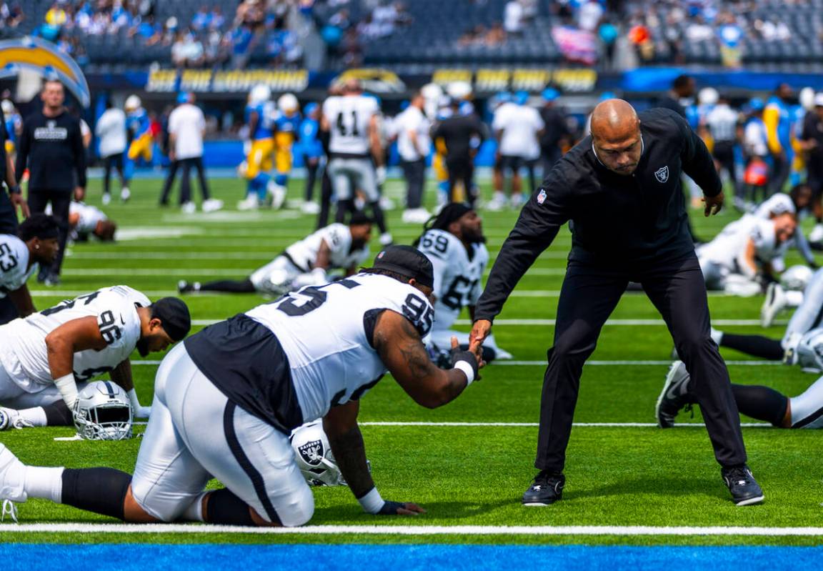 Raiders head coach Antonio Pierce greets defensive tackle John Jenkins (95) during warm ups dur ...