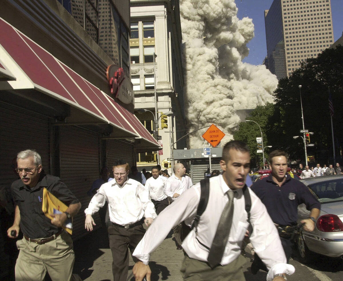 FILE - People run from a collapsing World Trade Center tower in New York, Sept. 11, 2001. (AP P ...