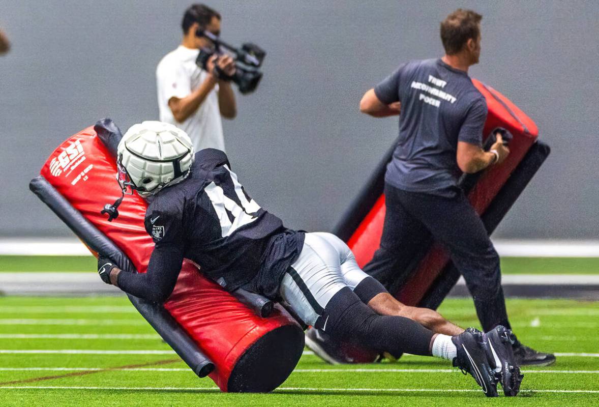 Raiders linebacker K'Lavon Chaisson (44) takes down a tackling dummy during practice at the Int ...