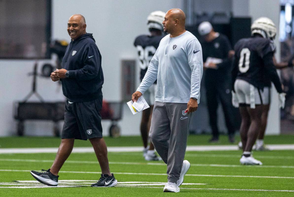 Raiders head coach Antonio Pierce talks with assistant coach Marvin Lewis during practice at th ...