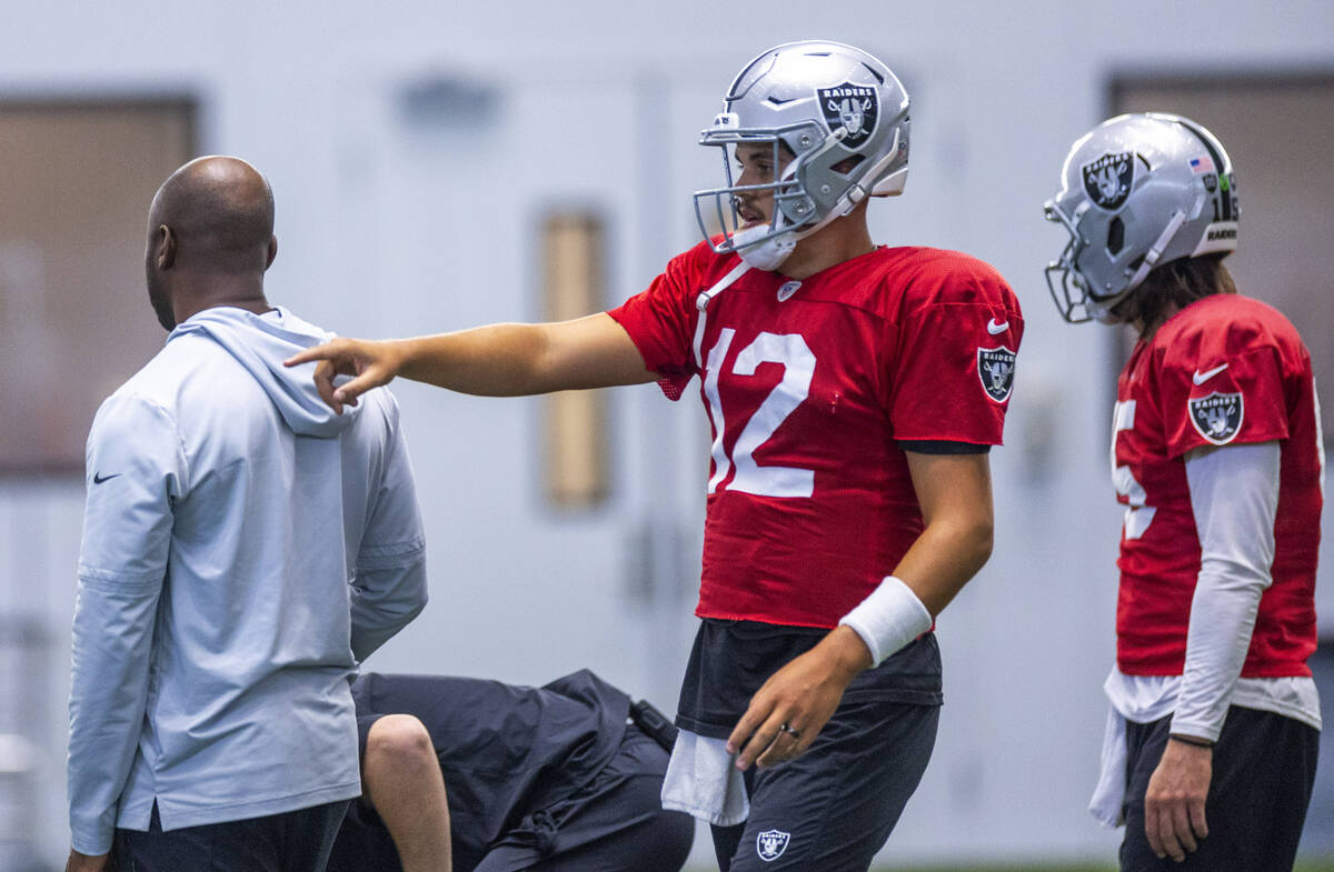 Raiders quarterback Aidan O'Connell (12) talks with quarterback Gardner Minshew (15) during pra ...