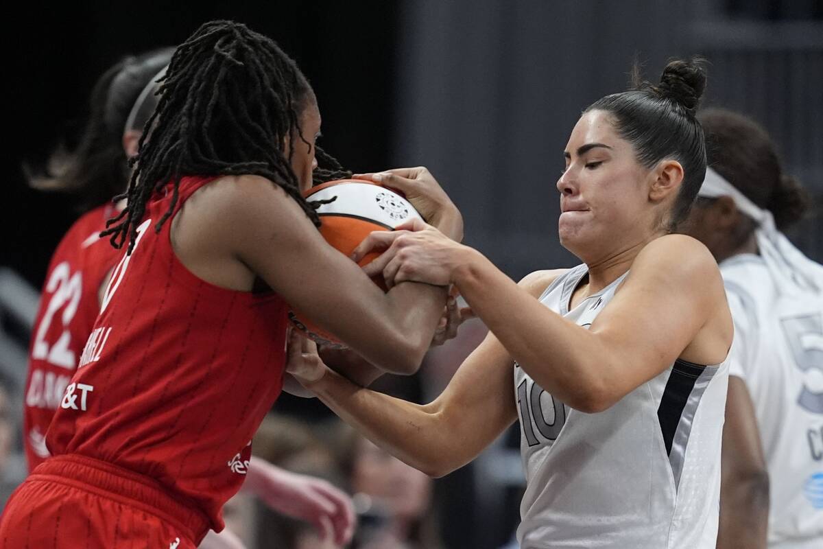 Indiana Fever's Kelsey Mitchell and Las Vegas Aces' Kelsey Plum battle for a loose ball during ...