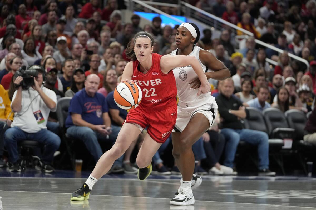 Indiana Fever's Caitlin Clark (22) goes to the basket against Las Vegas Aces' Jackie Young (0) ...