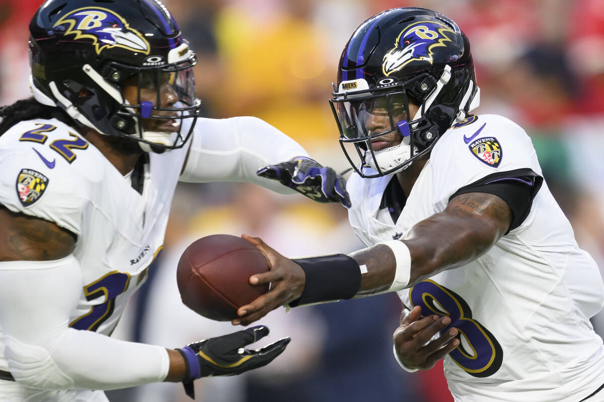 Baltimore Ravens quarterback Lamar Jackson (8) hands off to Baltimore Ravens running back Derri ...