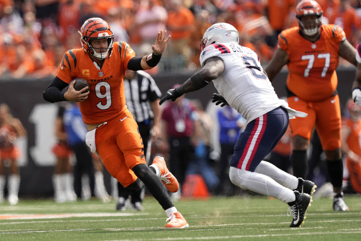 Cincinnati Bengals quarterback Joe Burrow (9) runs from New England Patriots linebacker Ja'Whau ...