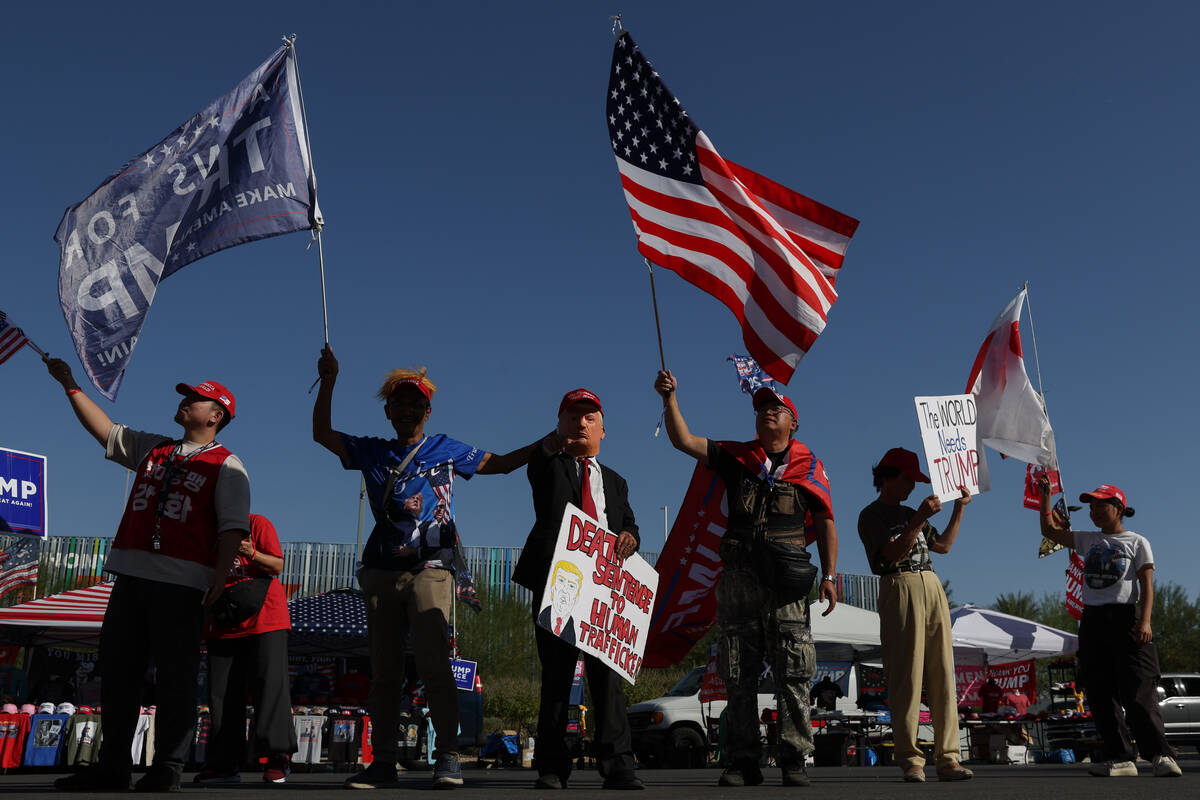 Supporters of former US President and Republican presidential candidate Donald Trump wave flags ...