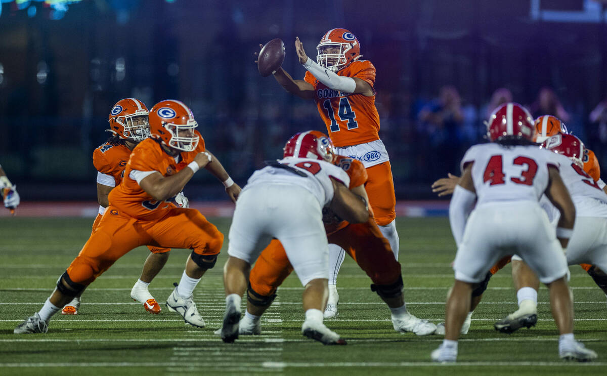 Bishop Gorman quarterback Maika Eugenio (14) reaches for an errant snap against Orange Lutheran ...