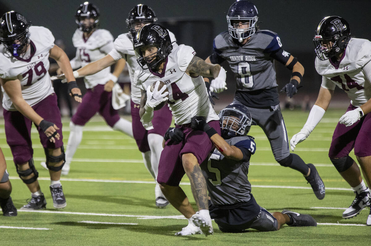 Shadow Ridge sophomore Isaiah Ruiz (5) attempts to tackle Faith Lutheran senior Cale Breslin (1 ...