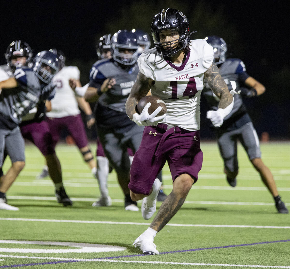 Faith Lutheran senior Cale Breslin (14) runs the ball during the high school football game agai ...