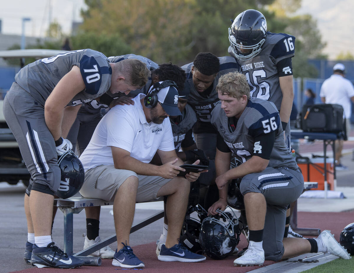 Shadow Ridge players watch film along the sideline during the high school football game against ...