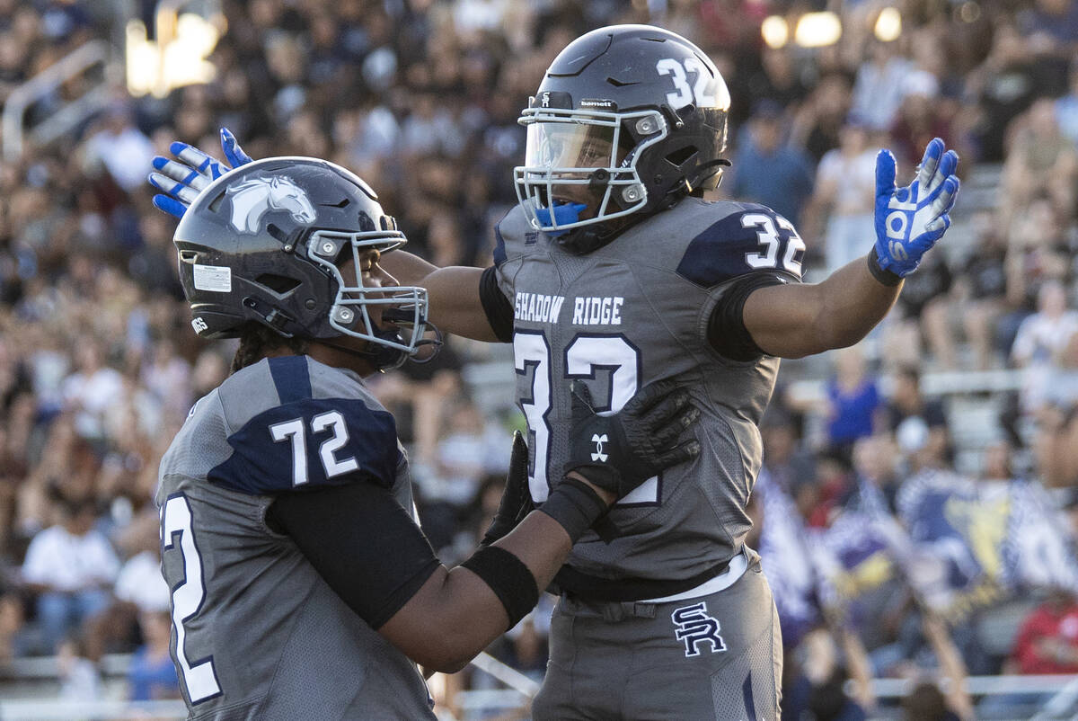 Shadow Ridge senior TyShaun Whitson (72) celebrates with senior Tyrell Craven (32) after scorin ...