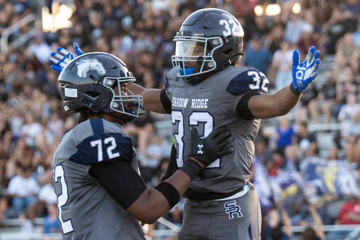 Shadow Ridge senior TyShaun Whitson (72) celebrates with senior Tyrell Craven (32) after scorin ...