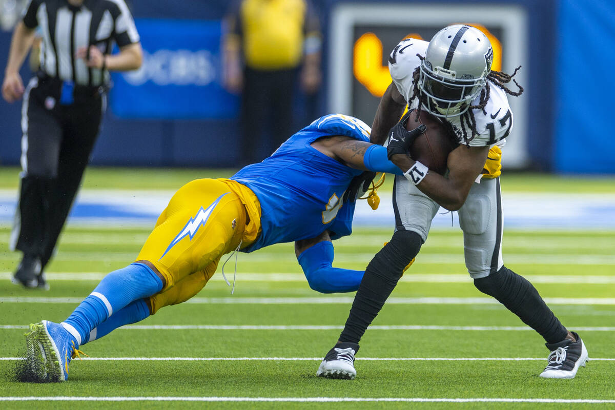 Raiders wide receiver Davante Adams (17) looks to avoid a tackle attempt by Los Angeles Charger ...