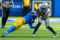 Raiders wide receiver Davante Adams (17) looks to avoid a tackle attempt by Los Angeles Charger ...