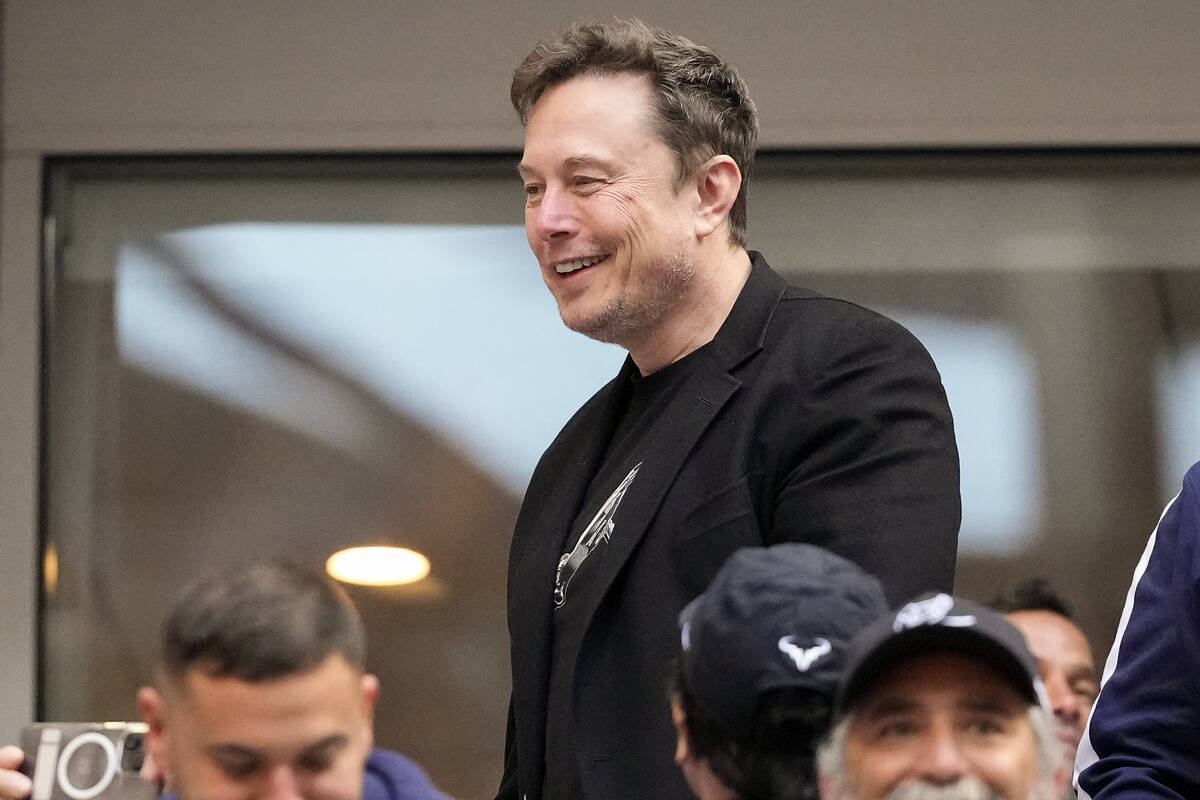 Elon Musk talks to other spectators while watching play between Jannik Sinner, of Italy, and Ta ...