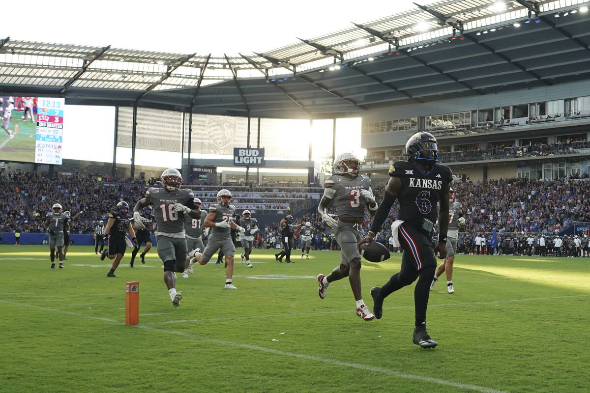 Kansas quarterback Jalon Daniels (6) runs into the end zone past UNLV defensive back Johnathan ...