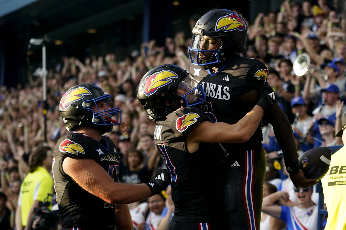 Kansas quarterback Jalon Daniels, right, celebrates after his touchdown run against UNLV with w ...