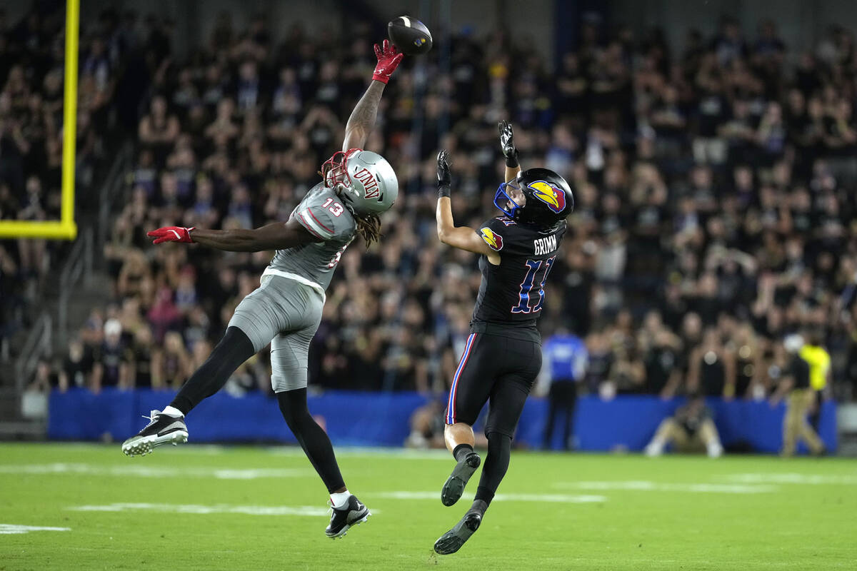 UNLV defensive back Jarvis Ware, left, tips the ball away from Kansas wide receiver Luke Grimm ...