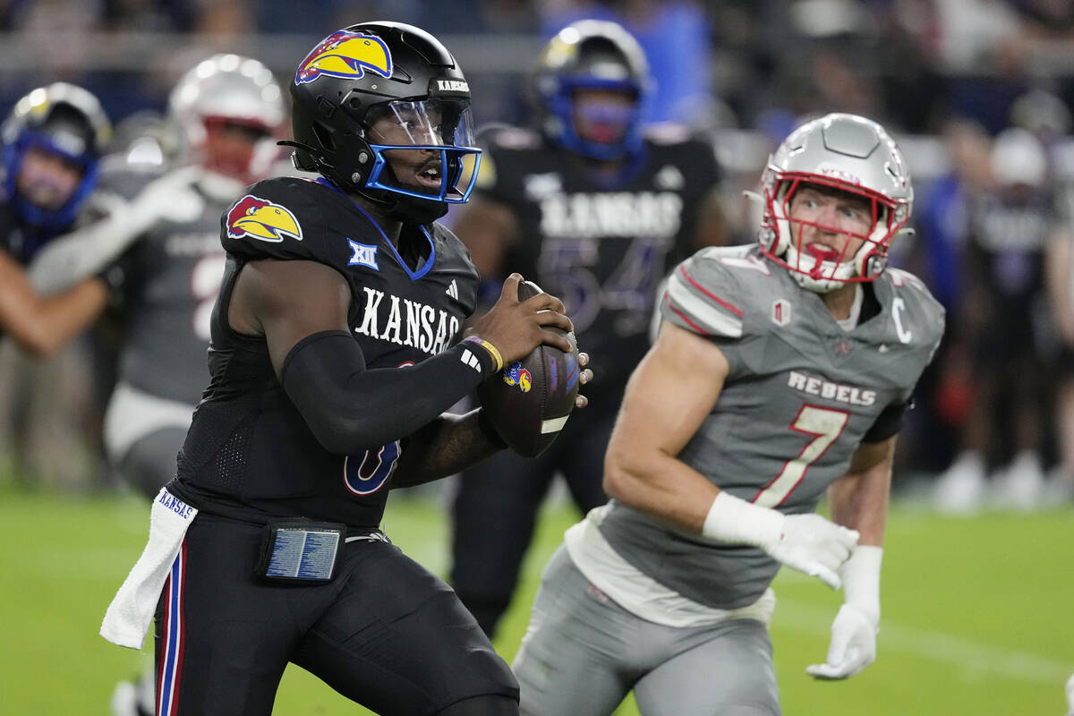 Kansas quarterback Jalon Daniels (6) runs against UNLV linebacker Jackson Woodard (7) in the se ...