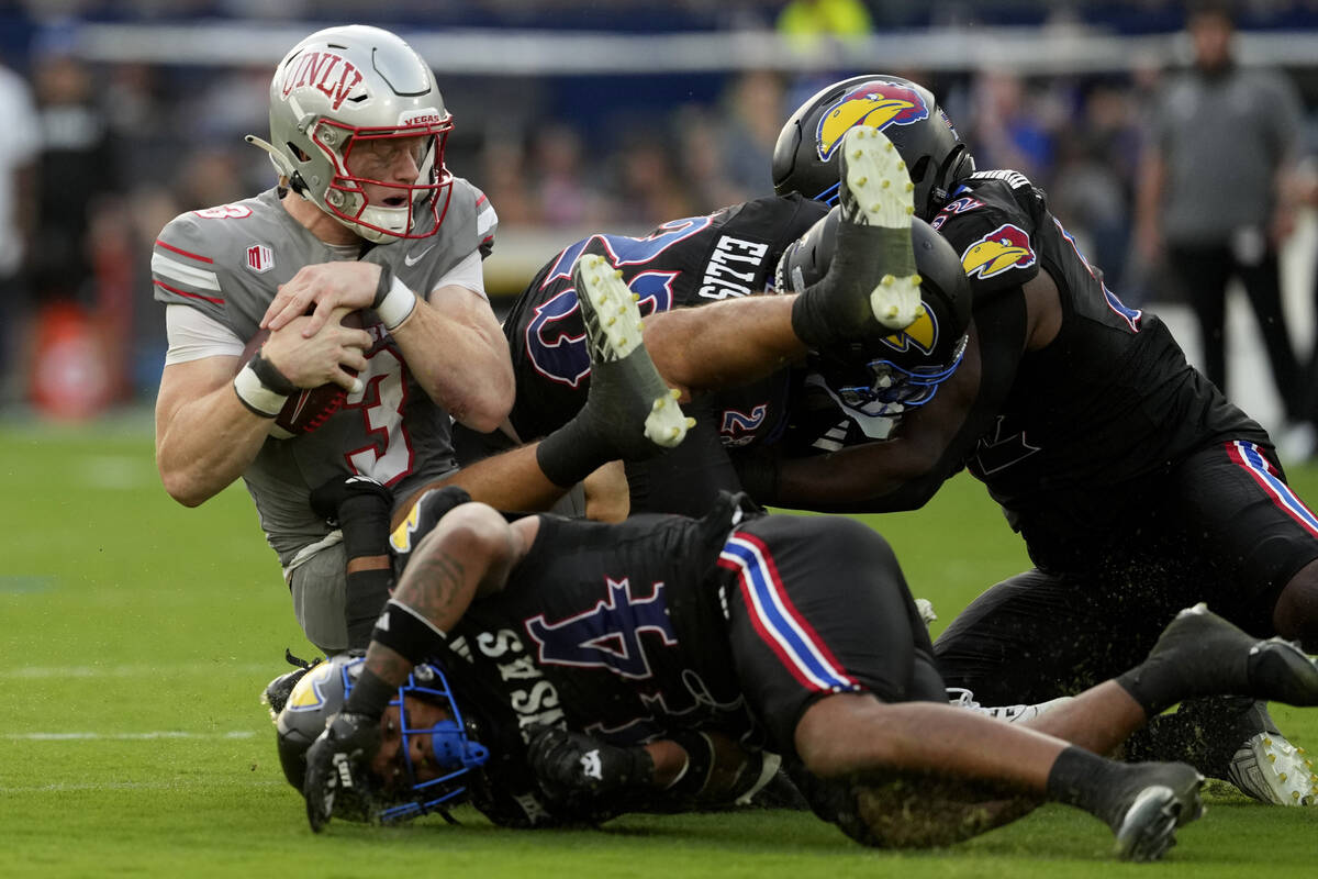 UNLV quarterback Matthew Sluka (3) is sacked by Kansas linebacker Cornell Wheeler (44) and safe ...